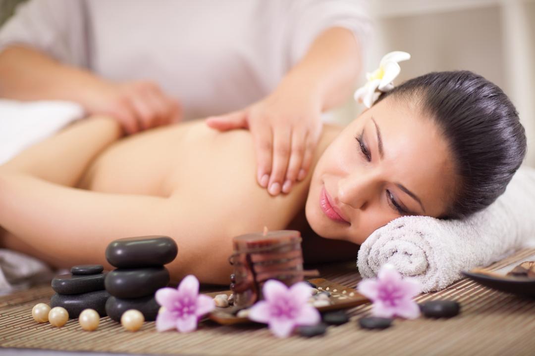 young woman having a wellness back massage at spa salon